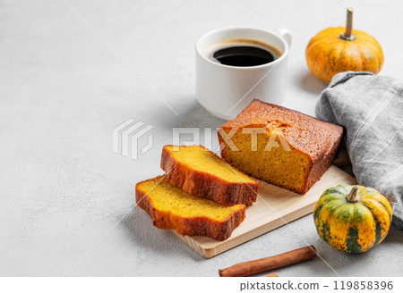 Slices of pumpkin sweet bread with cinnamon on a wooden board on a light background Slices of pumpkin sweet bread with cinnamon on a wooden board on a light background 119858396