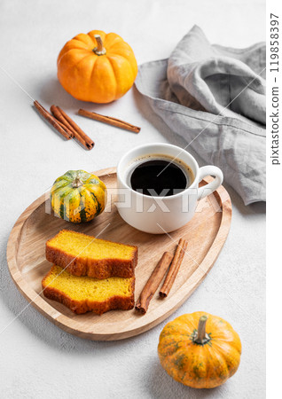 Slices of pumpkin sweet bread with cinnamon on a wooden board on a light  background  119858397