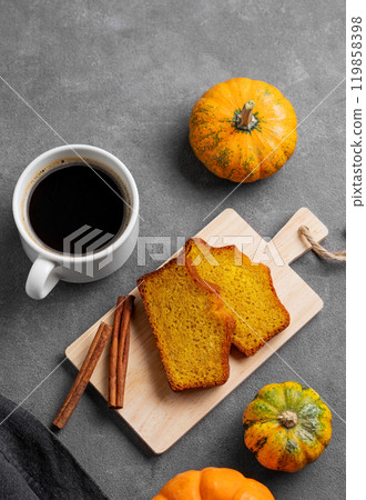 Slices of pumpkin sweet bread with cinnamon on a wooden board on a dark background Slices of pumpkin sweet bread with cinnamon on a wooden board on a dark background 119858398