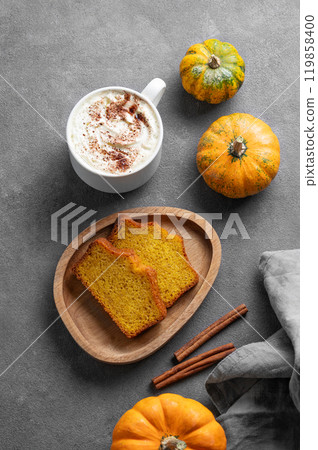 Slices of pumpkin sweet bread with cinnamon on a wooden board on a dark background  119858400