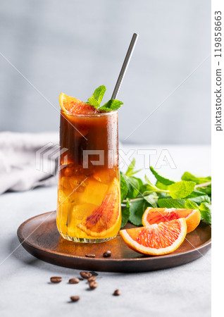 Coffee with orange juice (bumble) in a tall glass with ice and mint on a wooden plate  119858663