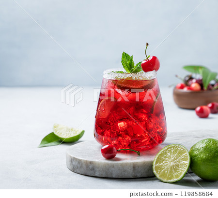 Cherry-lime mojito cocktail with mint, lime and ice on a marble  board on a light background  119858684