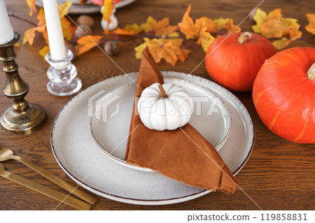 Autumn, fall, Halloween or Thanksgiving day table setting. Plates with yellow leaves and pumpkins Autumn, fall, Halloween or Thanksgiving day table setting. Plates with yellow leaves and pumpkins 119858831