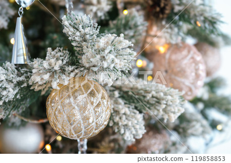 Frosted branches of Christmas tree with decorative gold and silver ornaments and shining lights Frosted branches of Christmas tree with decorative gold and silver ornaments and shining lights 119858853