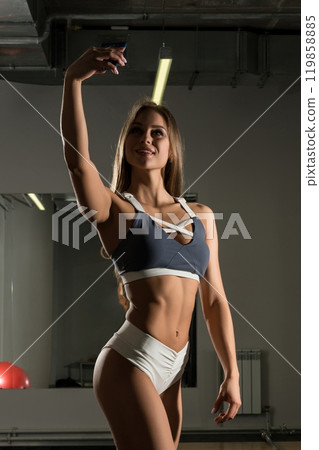 Pretty girl in gym with iphone full-length shot 119858885
