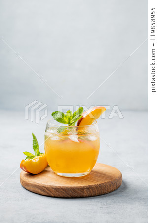 Refreshing peach cocktail, lemonade or iced tea on a wooden board on a light background. Refreshing peach cocktail, lemonade or iced tea on a wooden board on a light background. 119858955