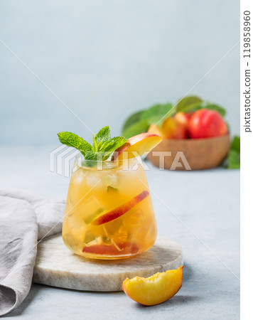 Refreshing peach cocktail, lemonade or iced tea on a marble board on a light background. Refreshing peach cocktail, lemonade or iced tea on a marble board on a light background. 119858960
