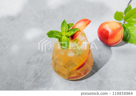 Refreshing peach cocktail, lemonade or iced tea on a blue background with summer shadows. 119858964