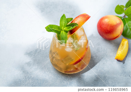 Refreshing peach cocktail, lemonade or iced tea on a blue background with summer shadows. 119858965