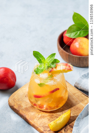 Refreshing peach cocktail, lemonade or iced tea on a wooden board on a blue background. Refreshing peach cocktail, lemonade or iced tea on a wooden board on a blue background. 119858966