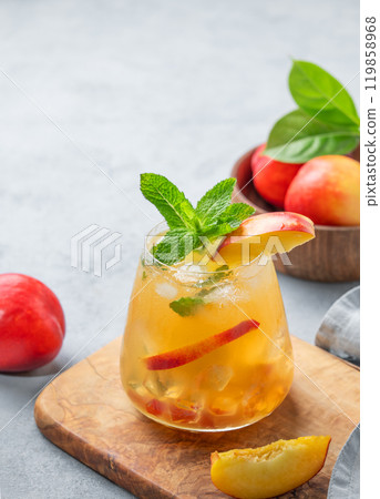 Refreshing peach cocktail, lemonade or iced tea on a wooden board on a light background. Refreshing peach cocktail, lemonade or iced tea on a wooden board on a light background. 119858968