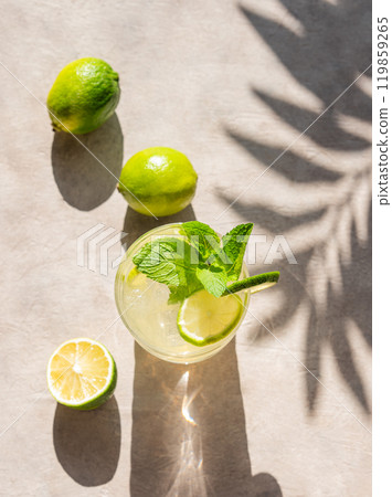 Lime mojito in a glass with mint and ice. Refreshing citrus cocktail on a light background  119859265