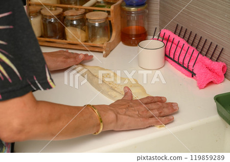 Woman folding dough to make buns Woman folding dough to make buns 119859289