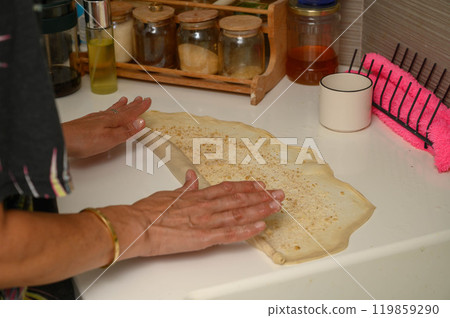 Woman rolling out dough to make buns Woman rolling out dough to make buns 119859290