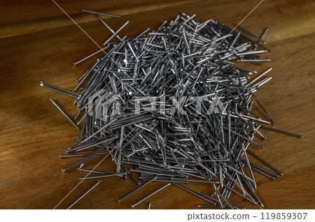 Pile of carpentry nails on a wooden table 119859307