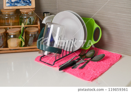 Drying rack with clean dishes on table in kitchen. Space for text Drying rack with clean dishes on table in kitchen. Space for text 119859361
