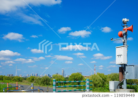 Disaster prevention administrative radio chime on the Arakawa River bank and white clouds in the blue sky Disaster prevention administrative radio chime on the Arakawa River bank and white clouds in the blue sky 119859449