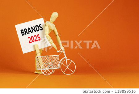 Planning brands 2025 new year symbol. Concept words Brands 2025 on beautiful white paper on wooden clothespin. Beautiful orange background. Bicycle. Business brands 2025 new year concept. Copy space. Planning brands 2025 new year symbol. Concept words Brands 2025 on beautiful white paper on wooden clothespin. Beautiful orange background. Bicycle. Business brands 2025 new year concept. Copy space. 119859516