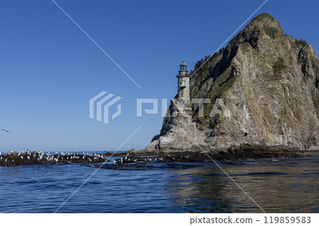 Aniva - The abandoned lighthouse in the Sakhalin Island, Korsakov district, Russia. Pacific ocean. The abandoned lighthouse Island Blue sea. Beautiful view. Blue sky and blue Pacific ocean. 119859583