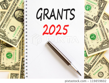 Planning grants 2025 new year symbol. Concept words Grants 2025 on beautiful white note. Beautiful background from dollar bills. Black pen. Business grants 2025 new year concept. Copy space. 119859602