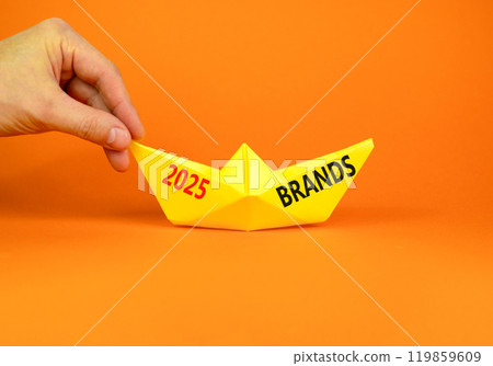 Planning 2025 brands new year symbol. Concept words 2025 Brands on beautiful yellow paper boat. Businessmen hand. Beautiful orange paper background. Business 2025 brands new year concept. Copy space. Planning 2025 brands new year symbol. Concept words 2025 Brands on beautiful yellow paper boat. Businessmen hand. Beautiful orange paper background. Business 2025 brands new year concept. Copy space. 119859609