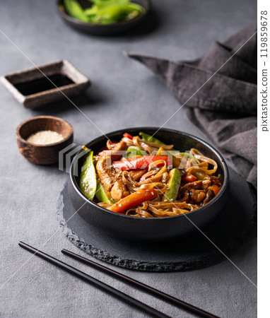 Stir-fry with soba noodles, meat and vegetables on dark background with napkin. 119859678