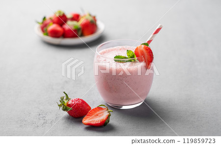 A glass of fresh strawberry smoothie with mint on a blue background with fresh berries. A glass of fresh strawberry smoothie with mint on a blue background with fresh berries. 119859723