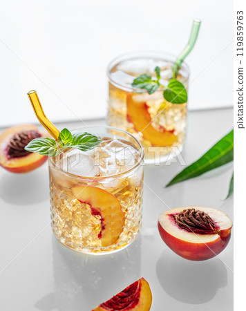 Homemade peach lemonade with ice and mint on white background. Fresh iced tea in glasses Homemade peach lemonade with ice and mint on white background. Fresh iced tea in glasses 119859763