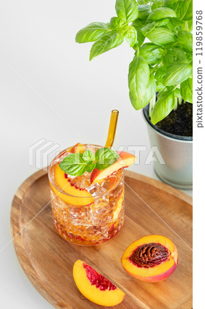 Peach refreshing drink with ice and mint on a wooden board on a white table. Fresh homemade lemonade Peach refreshing drink with ice and mint on a wooden board on a white table. Fresh homemade lemonade 119859768