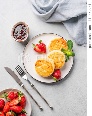 Cottage cheese, cheesecakes or syrniki with strawberries, berry jam and mint leaves Cottage cheese, cheesecakes or syrniki with strawberries, berry jam and mint leaves 119859971
