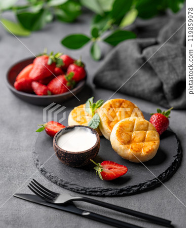 Cottage cheese, cheesecakes or syrniki with sour cream, strawberries and mint leaves Cottage cheese, cheesecakes or syrniki with sour cream, strawberries and mint leaves 119859978