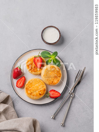 Cottage cheese, cheesecakes or syrniki with strawberries and mint leaves on a white plate Cottage cheese, cheesecakes or syrniki with strawberries and mint leaves on a white plate 119859983