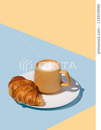 Coffee cup and fresh croissant on a white plate on a blue and yellow background. 119859990