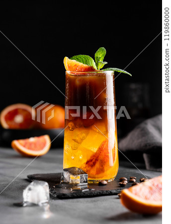 Coffee with orange juice (bumble) in a tall glass with ice and mint on a dark background Coffee with orange juice (bumble) in a tall glass with ice and mint on a dark background 119860000