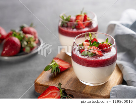Panna cotta with strawberry and cream in glasses with fresh berries on a wooden board  119860016