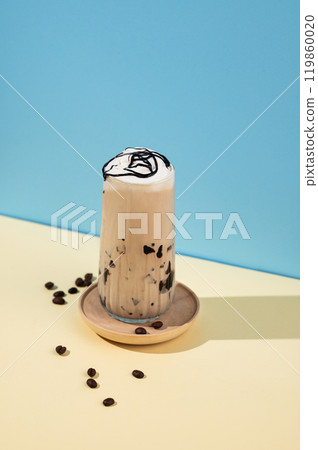 Iced coffee latte with chocolate in a tall glass with a milk on a blue and yellow background 119860020