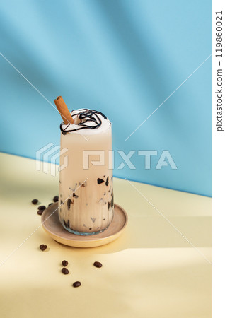 Iced coffee latte with chocolate and cinnamon in a tall glass with a milk  119860021