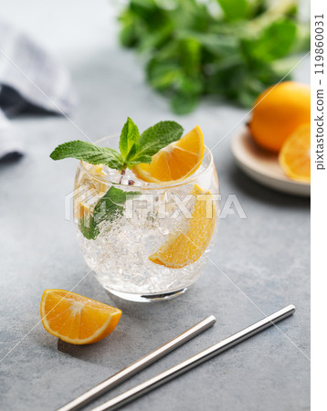 Lemonade tonic drink with fresh lemon, mint and ice on a light background with herb and fruits. Lemonade tonic drink with fresh lemon, mint and ice on a light background with herb and fruits. 119860031