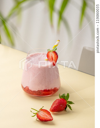 A strawberry milkshake or smoothie in glass with strawberries on a yellow background A strawberry milkshake or smoothie in glass with strawberries on a yellow background 119860035