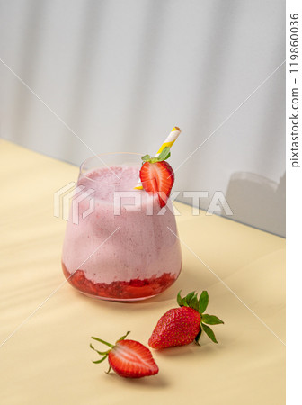 A strawberry milkshake or smoothie in glass with strawberries on a yellow background A strawberry milkshake or smoothie in glass with strawberries on a yellow background 119860036