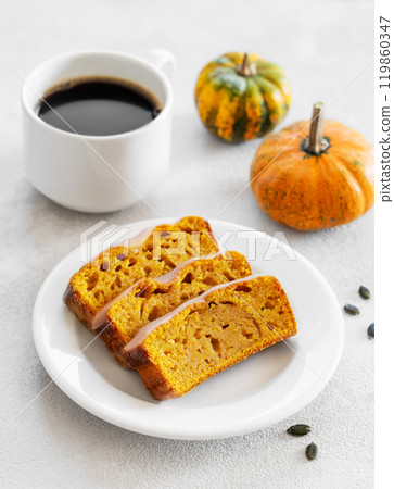 Slices of pumpkin sweet bread or cake with icing on a plate on a light background  119860347