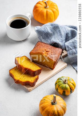Pumpkin sweet bread  on a wooden board on a light  background with decorative pumpkins 119860358