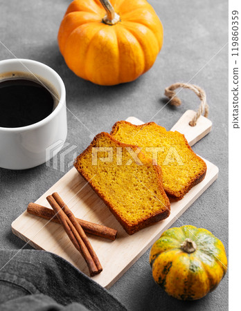 Slices of pumpkin sweet bread with cinnamon on a wooden board on a dark background Slices of pumpkin sweet bread with cinnamon on a wooden board on a dark background 119860359