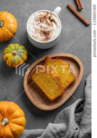 Slices of pumpkin sweet bread with cinnamon on a wooden board on a dark background with pumpkins Slices of pumpkin sweet bread with cinnamon on a wooden board on a dark background with pumpkins 119860366
