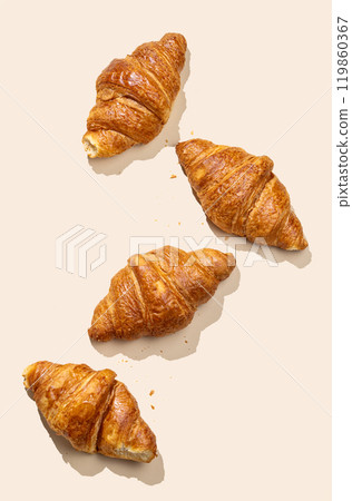 Flat lay of  fresh croissants on yellow  background with shadow. 119860367