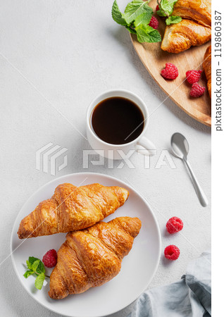 Cup of espresso coffee and croissants with fresh raspberries and mint on a plate  119860387