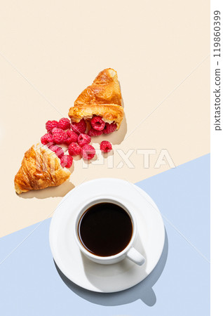 Cup of coffee and broken croissant with fresh  raspberries  on an yellow and blue background. 119860399