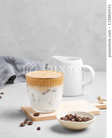 Iced dalgona coffee. Whipped instant coffee in a glass with ice on a wooden board 119860433