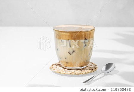 Dalgona coffee. Whipped instant coffee in a glass with ice on a white background Dalgona coffee. Whipped instant coffee in a glass with ice on a white background 119860488