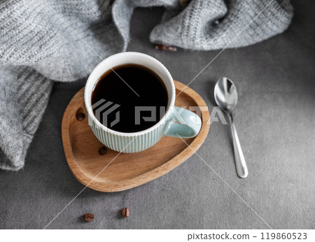 Espresso coffee in a mug on a wooden board on a dark background with coffee beans, spoon  119860523